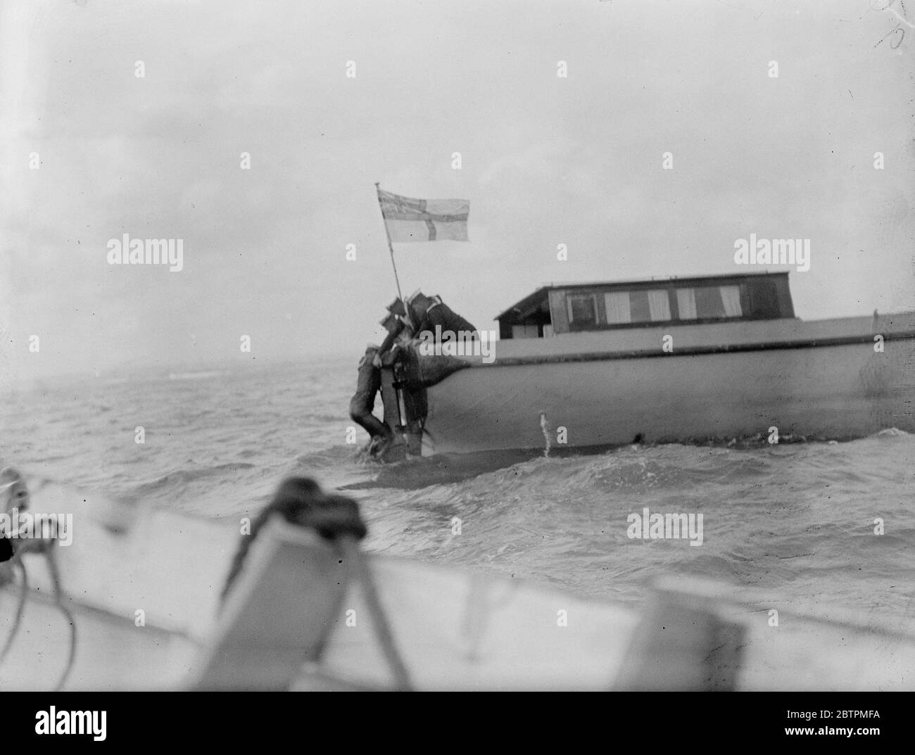 Accident aux manœuvres navales . King mène sa flotte à la mer pour la pratique de la bataille . L'homme qui est tombé à la mer de piquetage à l'extérieur du port de Portsmouth , grimpant dans le bateau après son sauvetage . 17 juillet 1935 Banque D'Images