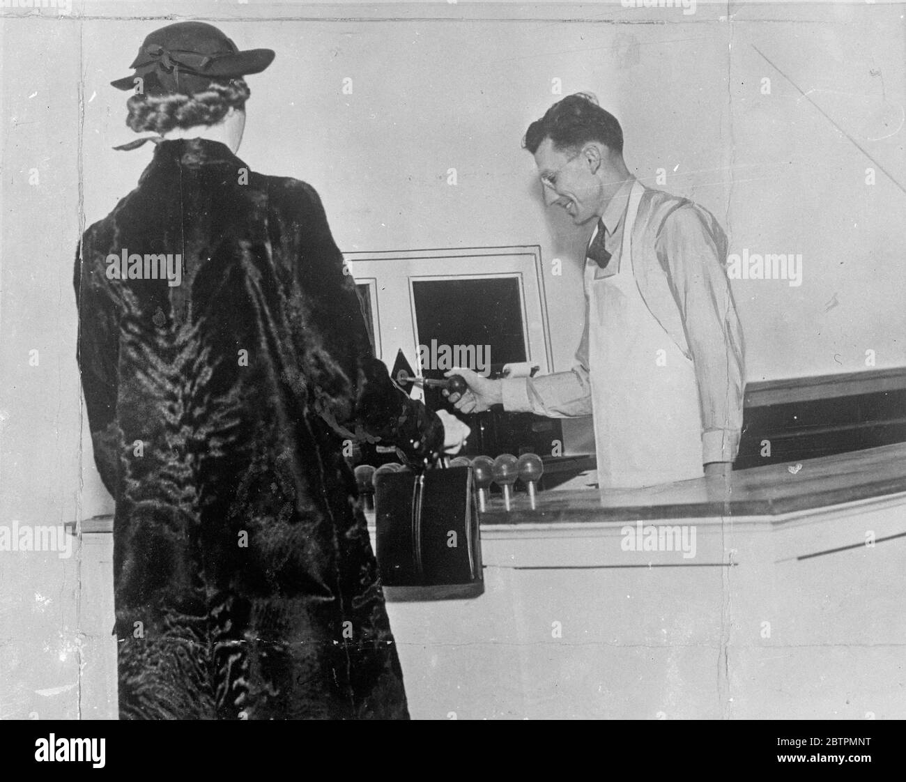 Magasin Keedoozle . Tout magasin électrique dans lequel les marchandises libérées par une clé spéciale et déposées sur un tapis de convoyeur et sont transportées à un emballeur qui est le seul à toucher les marchandises . La photo montre , le caissier insérant une clé dans le circuit principal qui libère la ceinture et transporte les marchandises vers le packer . Les marchandises sont toutes ajoutées et enregistrées dans la clé . Banque D'Images