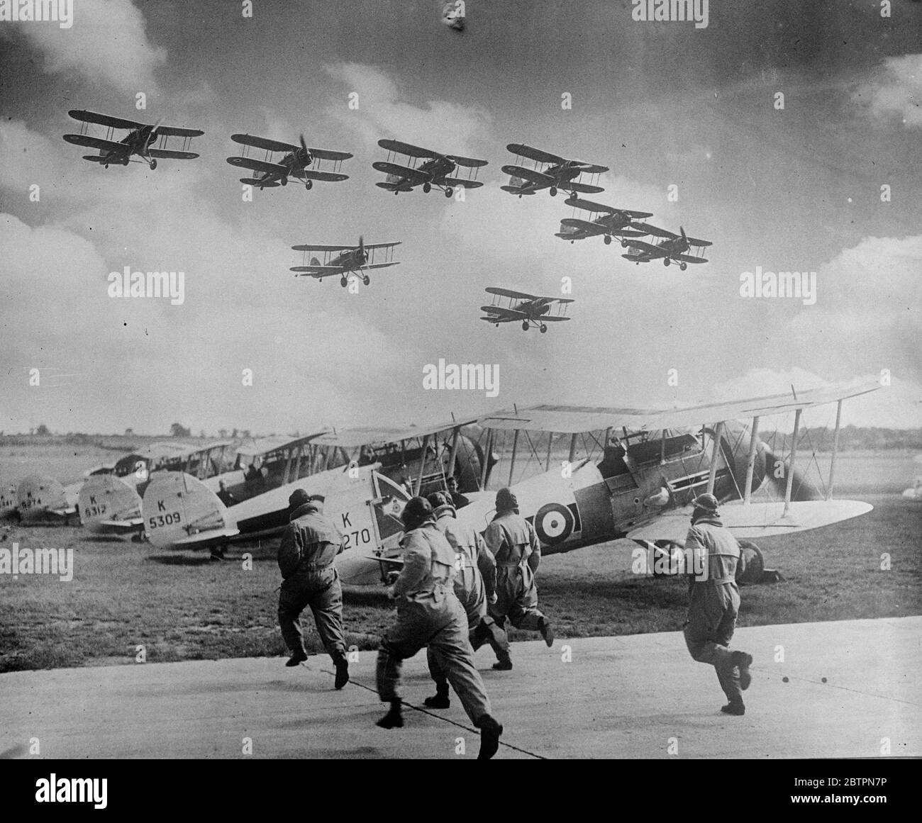 Attaque de réimpulsion RAF à Northolt. Répétition de l'Empire Day. Les pilotes de chasseurs et de bombardiers de la Royal Air Force ont répété à Northolt l'exposition de vol qu'ils donneront à la gare le jour de l'Empire Air, le 29 mai, lorsque l'aérodrome, en commun avec 52 autres unités de la RAF, sera ouvert à l'inspection publique. Des séances photo, défendant les pilotes de Gloster Geuntlet de l'escadron numéro 111 ( F ) se précipitent dans leurs avions pour répulver les machines attaquantes. 24 mai 1937 Banque D'Images
