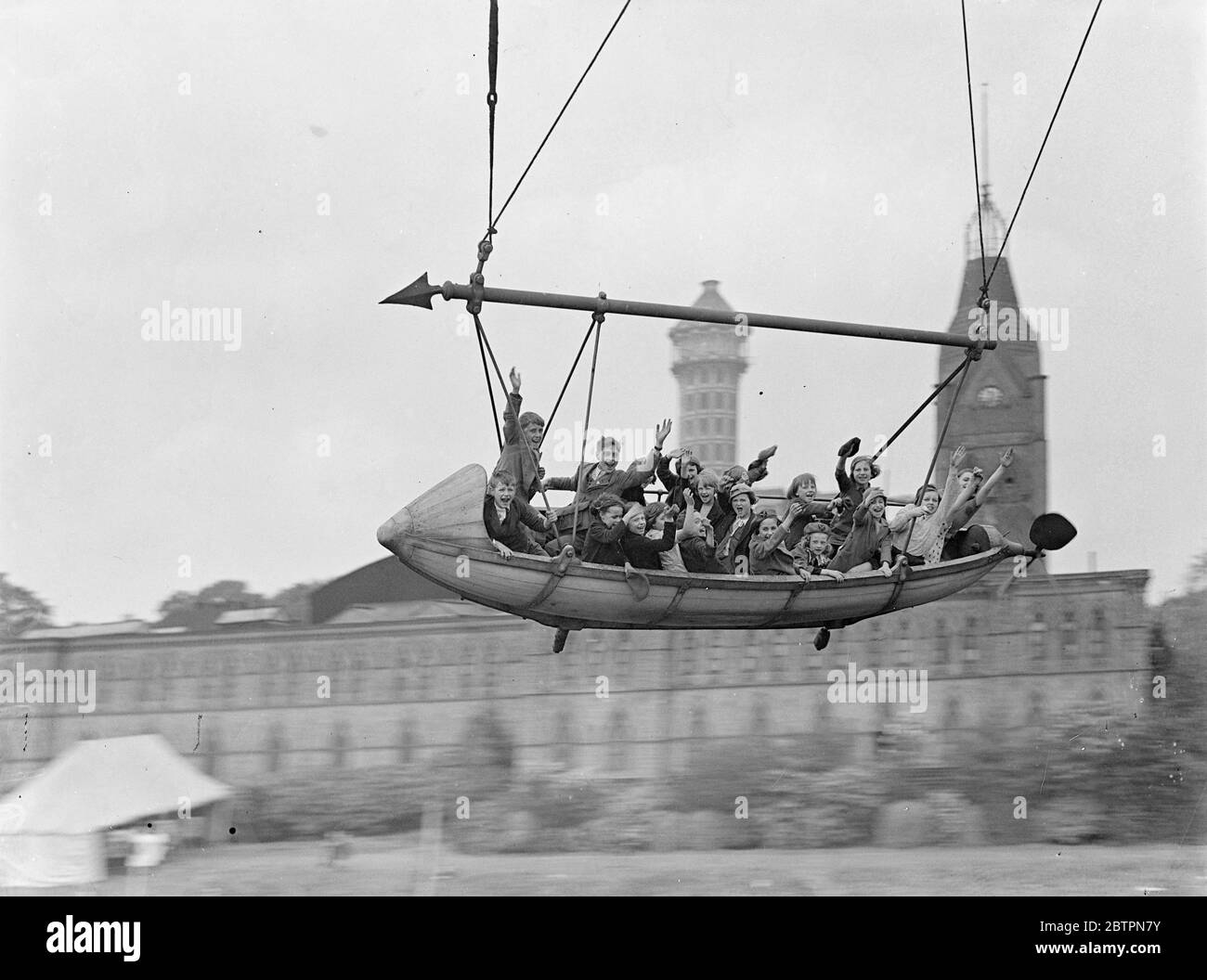 Leur 'Airship! '. 19,000 écoliers de Camberwell et d'autres quartiers du sud de Londres ont passé une journée au Crystal Palace pour un régal de Coronation. Les enfants ont eu le déjeuner et des animations. Des spectacles photo, une fête d'enfants qui profitent d'une promenade palpitante dans l'un des « bateaux volants ». 20 mai 1937 Banque D'Images