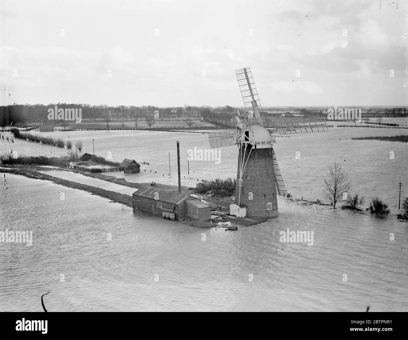 Photos par avion spécial. La mer balaie East Norfolk. Une nouvelle crise provoquée par la marée haute a fait face aujourd'hui aux villages inondés de la région de Horsey, dans le Norfolk (lundi). Les villages ont été inondés lorsque le Gale a frappé la mer, a éclaté les défenses côtières et a balayé l'intérieur des terres couvrant 20 miles.². La mer a forcé un écart de trois miles de long, considéré comme le plus grand fabriqué dans l'est du Norfolk pendant 50 ans, et a obligé 150 habitants de Horsey à quitter leurs maisons. Expositions de photos, le moulin à vent a maroné dans les inondations près de Horsey, Norfolk. 14 février 1938 Banque D'Images Photos par avion spécial. La mer balaie East Norfolk. Une nouvelle crise provoquée par la marée haute a fait face aujourd'hui aux villages inondés de la région de Horsey, dans le Norfolk (lundi). Les villages ont été inondés lorsque le Gale a frappé la mer, a éclaté les défenses côtières et a balayé l'intérieur des terres couvrant 20 miles.². La mer a forcé un écart de trois miles de long, considéré comme le plus grand fabriqué dans l'est du Norfolk pendant 50 ans, et a obligé 150 habitants de Horsey à quitter leurs maisons. Expositions de photos, le moulin à vent a maroné dans les inondations près de Horsey, Norfolk. 14 février 1938 Banque D'Images