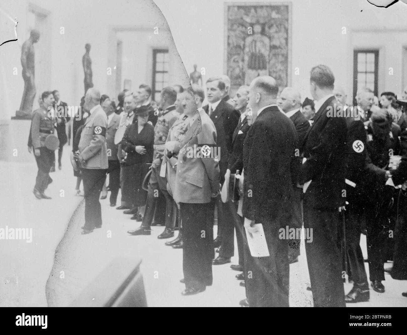 Hitler ouvre l'exposition d'art allemande. Découvrez l'exposition Londres. Une autre attaque contre l'art moderne et une référence sarcastique de l'exposition de peintures allemandes modernes qui se déroule actuellement à Londres ont été faites par le Chancelier Hitler à l'ouverture de la nouvelle exposition de peintures dans la Maison de l'art allemand, Munich. L'exposition de Londres, a-t-il dit, a été organisée à des fins politiques. C'était une autre tentative des ennemis de l'Allemagne nazie de minimiser les réalisations culturelles du National socialiste. Expositions de photos, Hitler lors de sa visite de l'exposition dans la Maison de l'Art allemand 11 juillet 1938 Banque D'Images