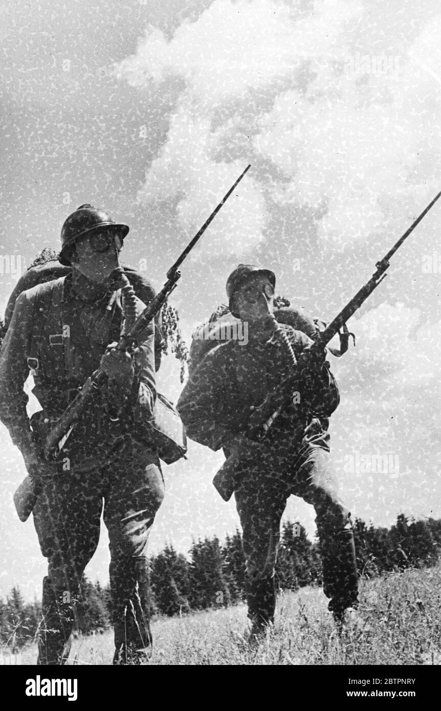 Prêt pour l'ennemi. Même les masques à gaz sans expression sont faits pour enregistrer la détermination par ces soldats de l'Armée rouge lorsqu'ils avancent à l'attaque pendant les exercices tactiques. 15 février 1938 Banque D'Images