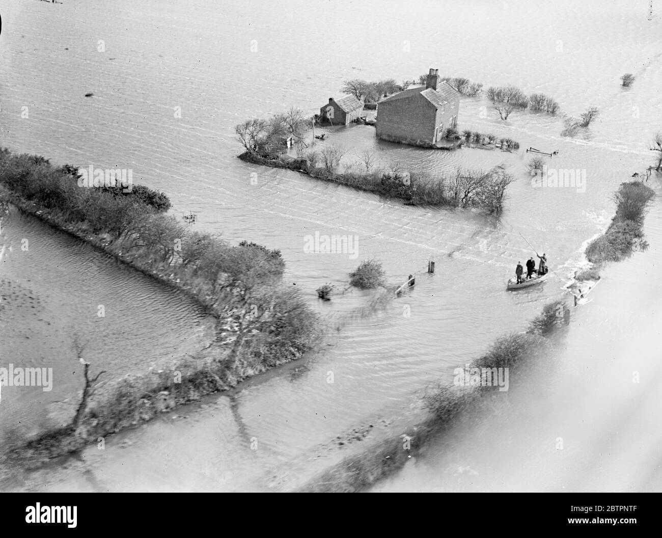 Photos par avion spécial. La mer balaie East Norfolk. Une nouvelle crise provoquée par la marée haute a fait face aujourd'hui aux villages inondés de la région de Horsey, dans le Norfolk (lundi). Les villages ont été inondés lorsque le Gale a frappé la mer, a éclaté les défenses côtières et a balayé l'intérieur des terres couvrant 20 miles.². La mer a forcé un écart de trois miles de long, considéré comme le plus grand fabriqué dans l'est du Norfolk pendant 50 ans, et a obligé 150 habitants de Horsey à quitter leurs maisons. Photos montre, les gens sont sauvés par bateau de je suis une ferme en ruines près de Horsey. 14 février 1938 Banque D'Images Photos par avion spécial. La mer balaie East Norfolk. Une nouvelle crise provoquée par la marée haute a fait face aujourd'hui aux villages inondés de la région de Horsey, dans le Norfolk (lundi). Les villages ont été inondés lorsque le Gale a frappé la mer, a éclaté les défenses côtières et a balayé l'intérieur des terres couvrant 20 miles.². La mer a forcé un écart de trois miles de long, considéré comme le plus grand fabriqué dans l'est du Norfolk pendant 50 ans, et a obligé 150 habitants de Horsey à quitter leurs maisons. Photos montre, les gens sont sauvés par bateau de je suis une ferme en ruines près de Horsey. 14 février 1938 Banque D'Images