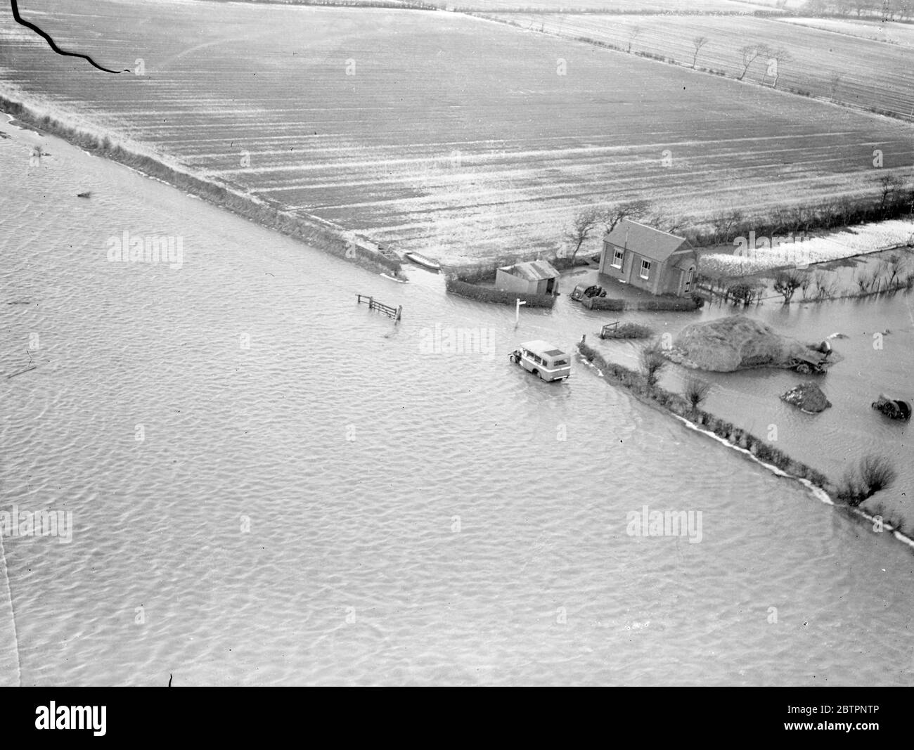 Photos par avion spécial. La mer balaie East Norfolk. Une nouvelle crise provoquée par la marée haute a fait face aujourd'hui aux villages inondés de la région de Horsey, dans le Norfolk (lundi). Les villages ont été inondés lorsque le Gale a frappé la mer, a éclaté les défenses côtières et a balayé l'intérieur des terres couvrant 20 miles.². La mer a forcé un écart de trois miles de long, considéré comme le plus grand fabriqué dans l'est du Norfolk pendant 50 ans, et a obligé 150 habitants de Horsey à quitter leurs maisons. Expositions de photos, bâtiments agricoles et haystacks au milieu des inondations entre Horsey et Wraxham, Norfolk. 14 février 1938 Banque D'Images Photos par avion spécial. La mer balaie East Norfolk. Une nouvelle crise provoquée par la marée haute a fait face aujourd'hui aux villages inondés de la région de Horsey, dans le Norfolk (lundi). Les villages ont été inondés lorsque le Gale a frappé la mer, a éclaté les défenses côtières et a balayé l'intérieur des terres couvrant 20 miles.². La mer a forcé un écart de trois miles de long, considéré comme le plus grand fabriqué dans l'est du Norfolk pendant 50 ans, et a obligé 150 habitants de Horsey à quitter leurs maisons. Expositions de photos, bâtiments agricoles et haystacks au milieu des inondations entre Horsey et Wraxham, Norfolk. 14 février 1938 Banque D'Images