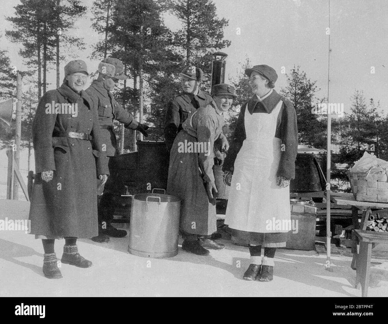 Femmes 'soldier' de Finlande. Ils cuisinent dans une cuisine de campagne ! Les militaires en uniforme de l'organisation patriotique finlandaise « Lottas » utilisent une cuisine de campagne pour remplir le devoir féminin ou préparer des aliments pour les concurrents aux championnats du monde de ski de Lahti, en Finlande. Une des femmes porte un tablier sur son grand manteau. 26 février 26 1938 Banque D'Images