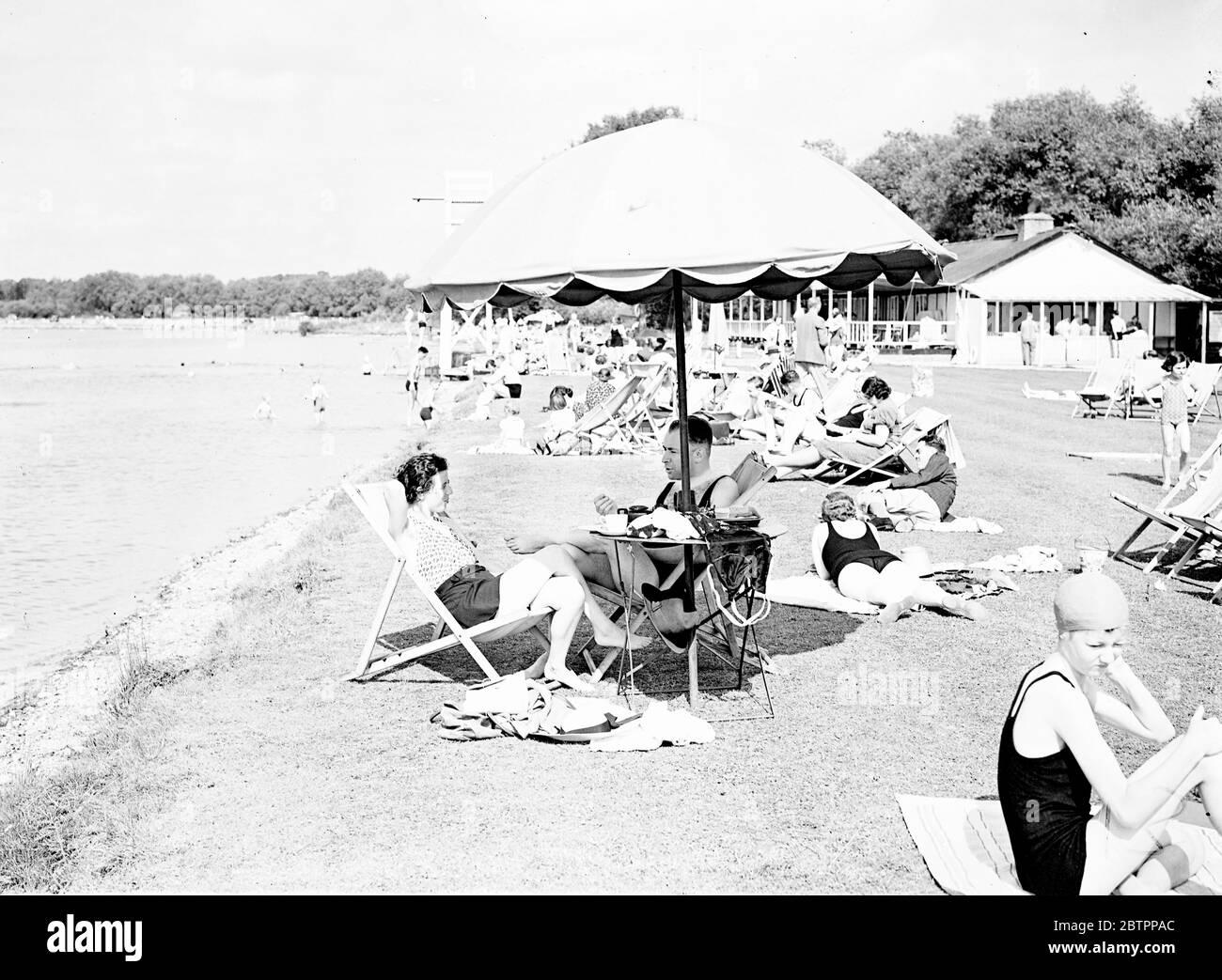 Vacances paresseuses. Le soleil éclatant a amené de nombreux vacanciers à l'Aquadrome de Rickmansworth, Hertfordshire, aujourd'hui (dimanche). Expositions de photos, baigneurs se lassant au soleil à Rickmansworth Aquadrome. 31 juillet 1938 Banque D'Images