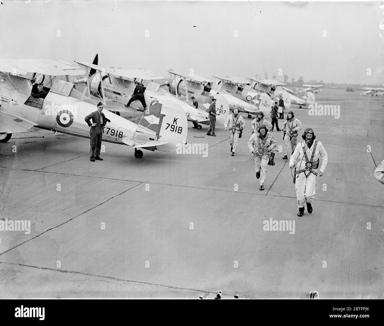 Air 'guerre' en Grande-Bretagne. Les aviateurs du 54 Escadron se bousculent pour entrer en action. Les gladiateurs Gloster de RAF Northolt participent à la plus grande guerre aérienne de Grande-Bretagne, les exercices aériens de défense à domicile, qui a « éclaté » dans une zone s'étendant de l'estuaire de la Tamise à l'embouchure du Humber. Expositions de photos, pilotes de chasse Westland qui se présentent à leurs machines à RAF Northolt, Essex. 5 août 1938 Banque D'Images