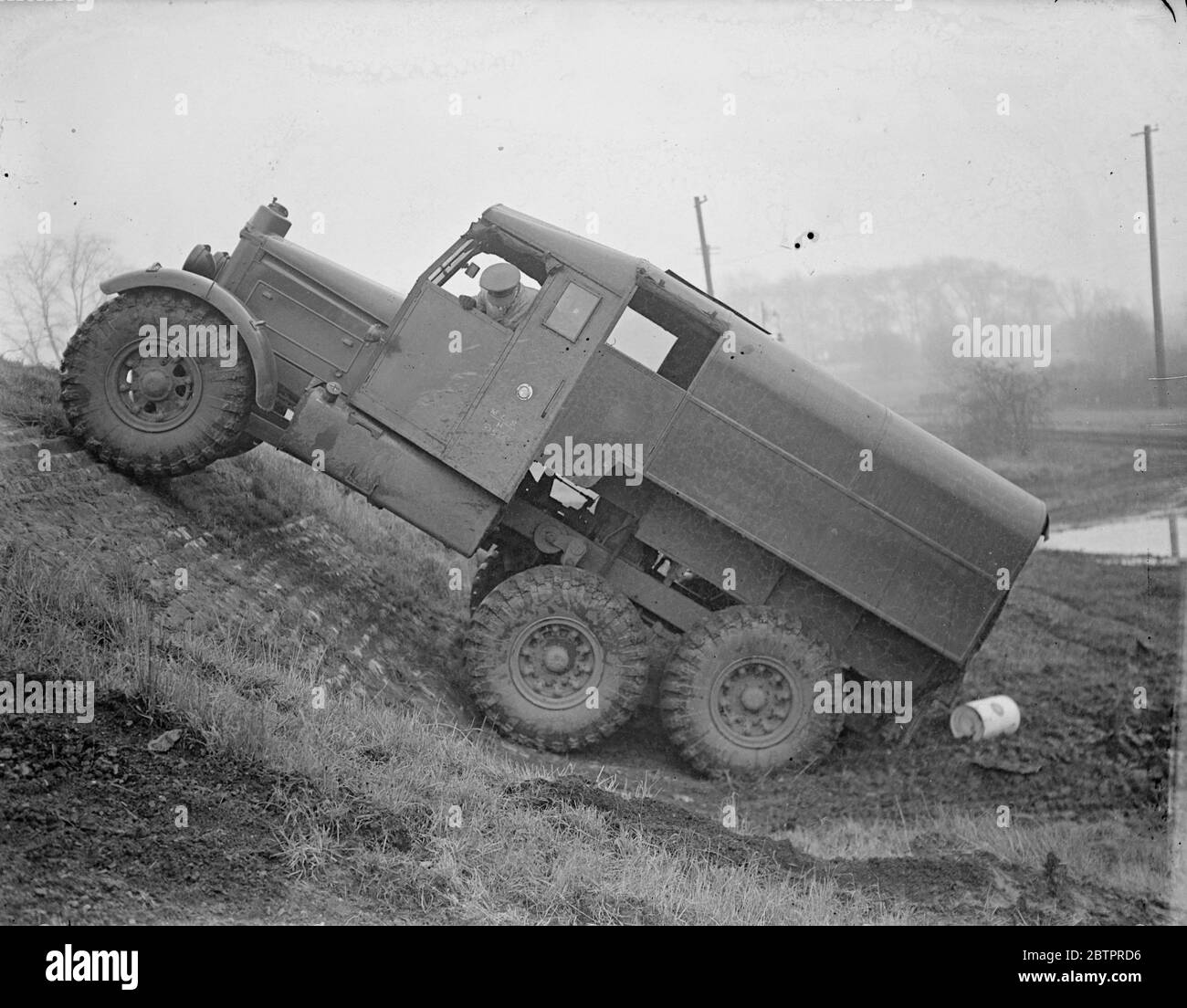 Des banderoles pour la « prière » ! Un lourd camion militaire à six roues « bondit » lui-même comme un animal au printemps, alors qu'il monte une pente raide à Woolwich Arsenal, Londres, où les instructeurs de la nouvelle armée mécanisée de Grande-Bretagne sont formés. Les jeunes hommes choisis parmi différentes unités d'artillerie sont soumis à un cours intensif sur la manutention de chars, de tracteurs et de camions de transport à l'Arsenal, avant de retourner à leurs propres unités en tant qu'instructeurs. 8 janvier 1938 Banque D'Images