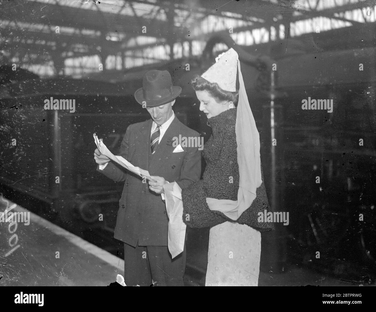 Chapeau médiéval de mode. Miss M Peters dans un chapeau attrayant de la mode de «mediaeval'style à la gare de Waterloo, Londres, quand les passagers ont quitté le train de bateau 'Queen Mary'pour l'Amérique. 10 novembre 1937 Banque D'Images