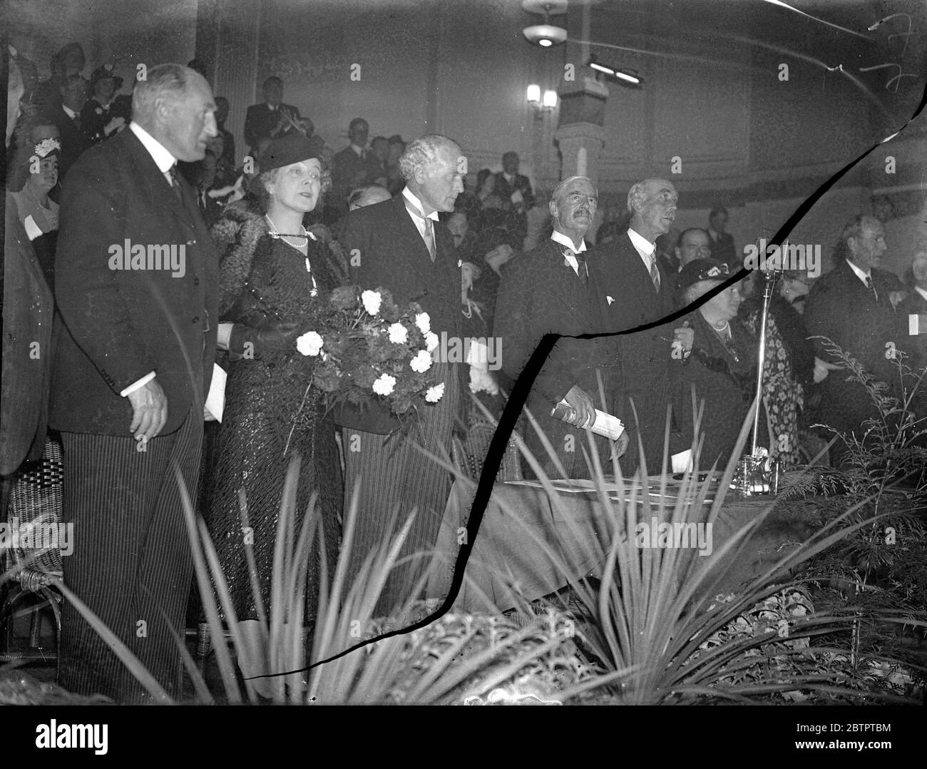 M. Chamberlain sur la plate-forme. De gauche à droite : Sir Eugene Ramsden, président de la région du Yorkshire; Mme Chamberlain; M. Douglas Hacking; M. Chamberlain; Lord Bingley (président de la réunion); et Mme Claire Fife (présidente de la conférence). M. Neville Chamberlain, le premier ministre a fait l'un des discours les plus importants de sa carrière lorsqu'il s'est adressé à 5000 personnes après la conférence du parti conservateur à Scarborough. Il a accueilli avec satisfaction le récent discours de M. results dénonçant les briseurs de traité et a déclaré que le gouvernement britannique coopérerait de tout cœur avec le président américain. 9 octobre 1937. Banque D'Images