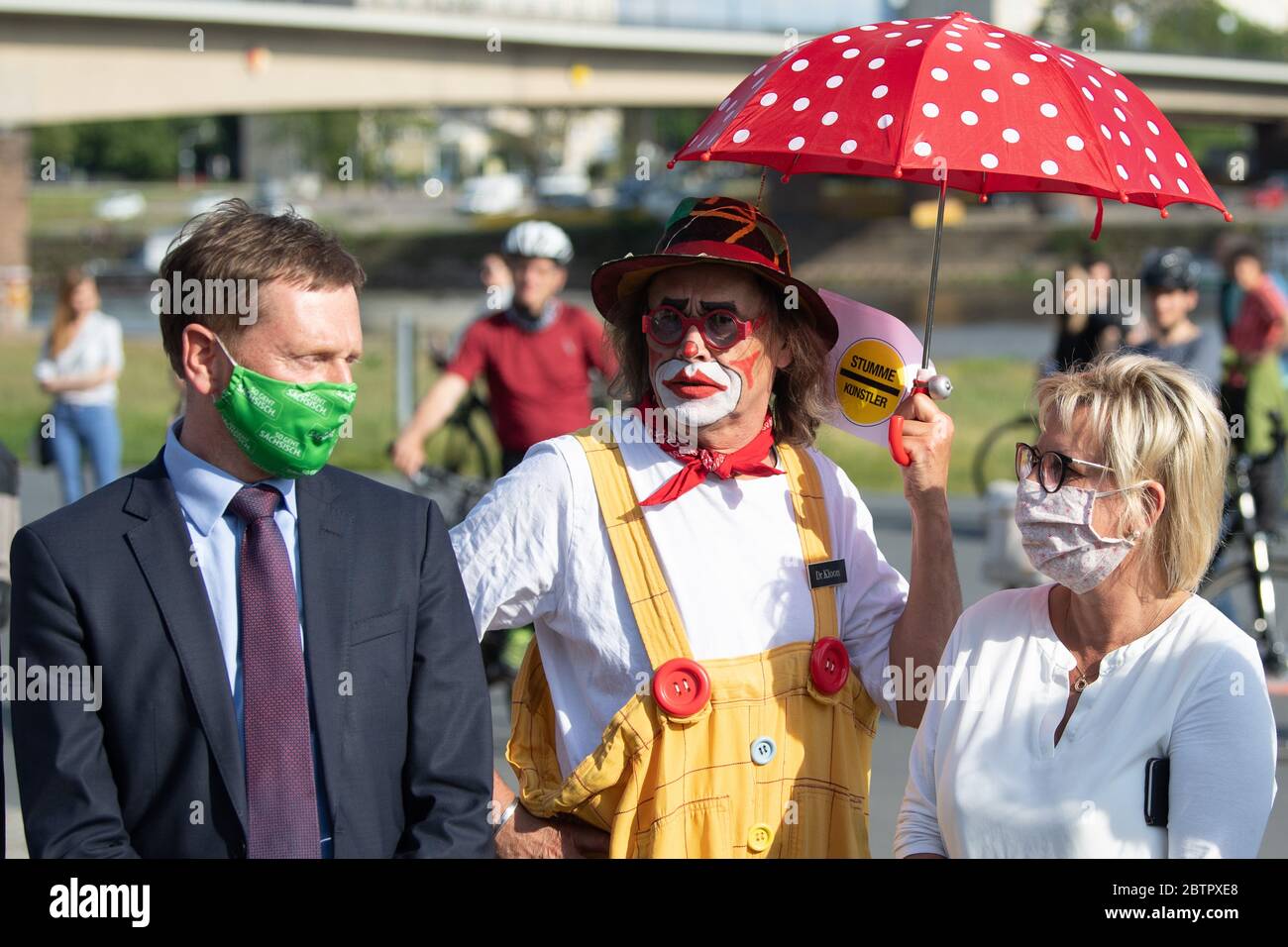 Dresde, Allemagne. 27 mai 2020. Un participant à une manifestation intitulée « artistes silencieux » se tient sur les rives de l'Elbe dans un costume de clown entre Michael Kretschmer, Premier ministre de Saxe, et Barbara Klepsch (deux CDU), ministre de la Culture et du Tourisme de Saxe. Le rassemblement vise à sensibiliser les gens aux problèmes majeurs auxquels sont confrontés les industries culturelles libres en Saxe. Credit: Sebastian Kahnert/dpa-Zentralbild/dpa/Alay Live News Banque D'Images