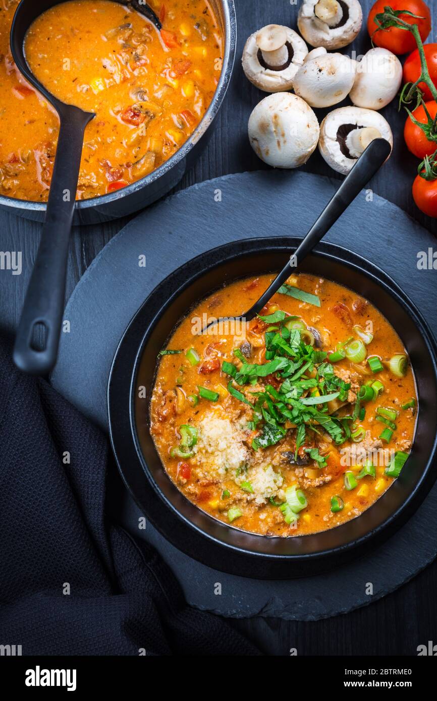 Soupe à la pizza - utilisation de restes pour la cuisson. Soupe maison fraîche avec tomate, champagnon, bœuf, maïs et mozzarella Banque D'Images