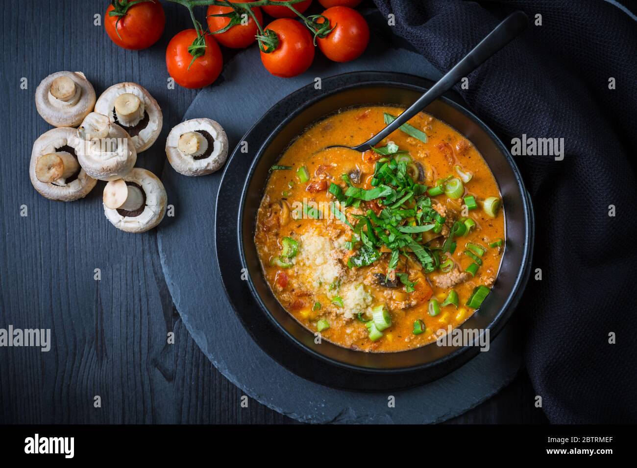 Soupe à la pizza - utilisation de restes pour la cuisson. Soupe maison fraîche avec tomate, champagnon, bœuf, maïs et mozzarella Banque D'Images
