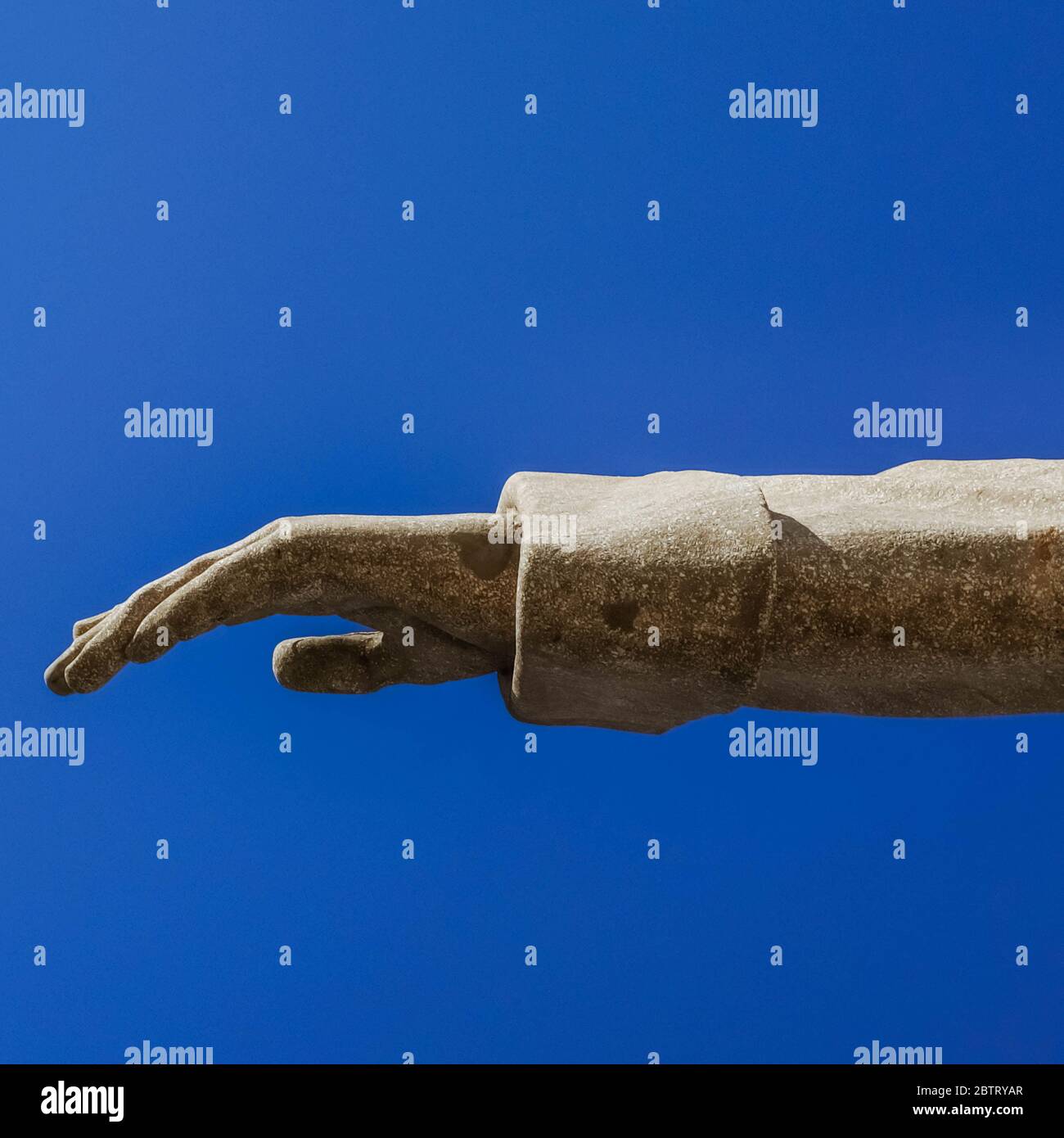 Main de sculpture de Jésus Christ avec ciel bleu clair sur fond. Banque D'Images