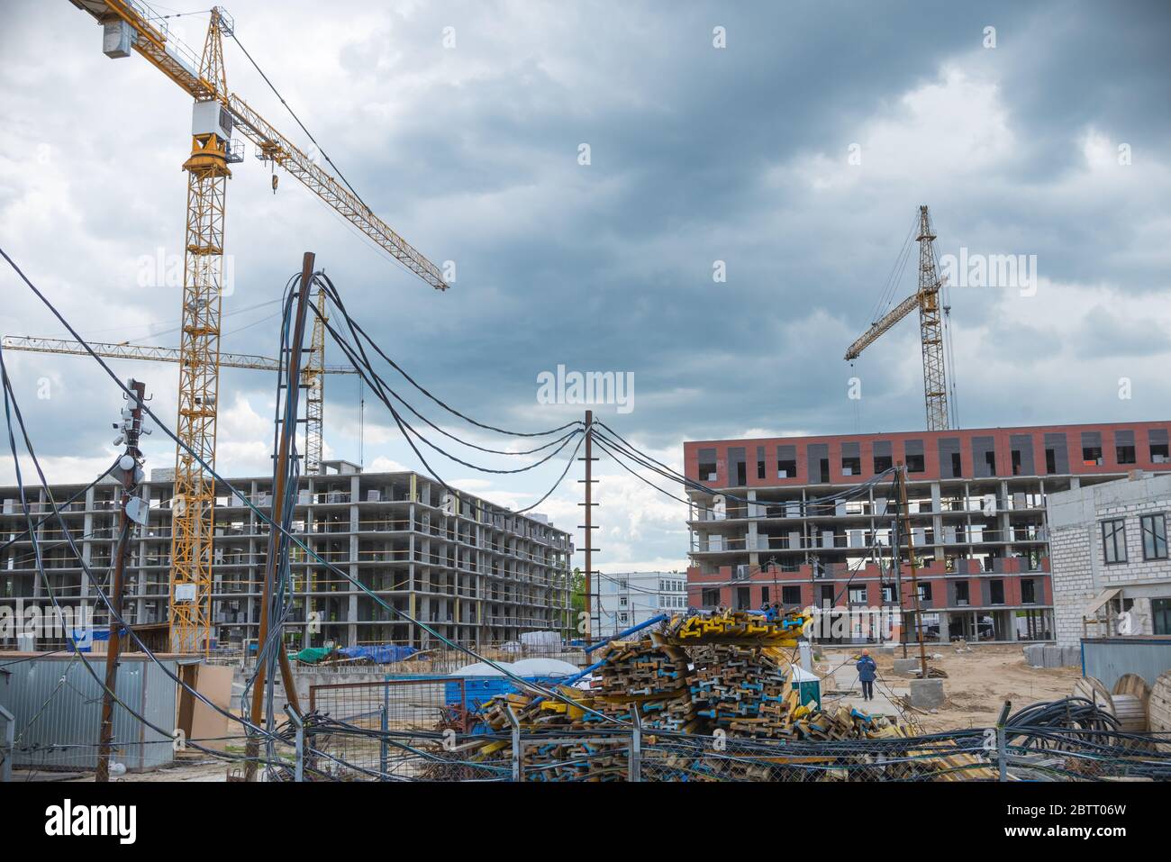 Grues de construction près des bâtiments non finis. Construction et développement de nouveaux districts Banque D'Images