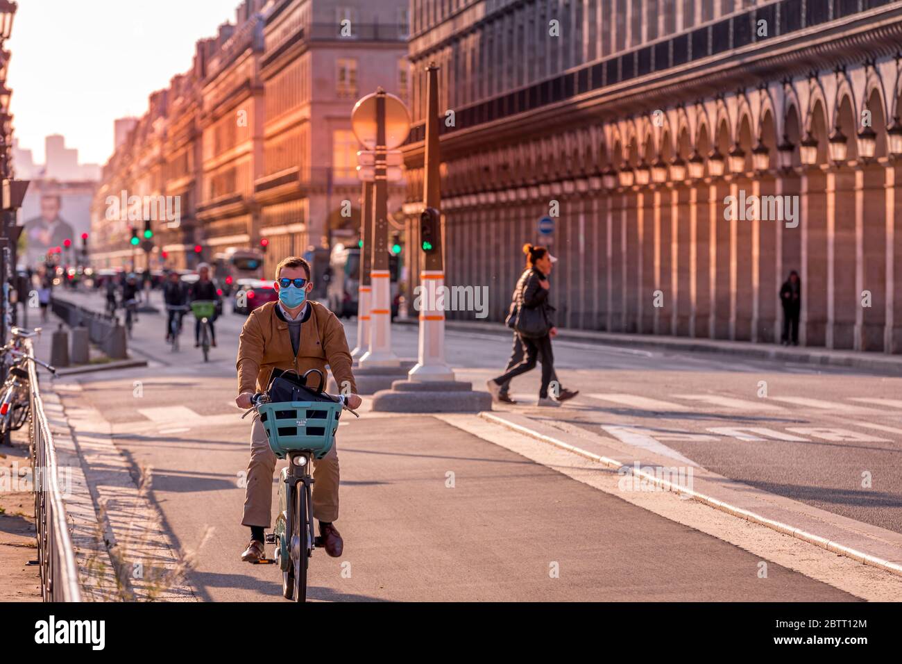 Paris, France - 14 mai 2020 : homme sur son vélo avec un masque chirurgical pour se protéger du covid-19 dans une rue de Paris Banque D'Images