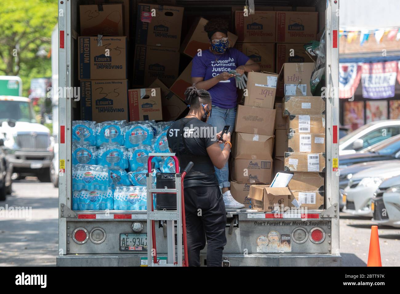 Les travailleurs et les bénévoles déchargent les dons alimentaires aux maisons Queensbridge, un complexe de logements publics de la New York City Housing Authority (NYCHA), le 27 mai 20 Banque D'Images