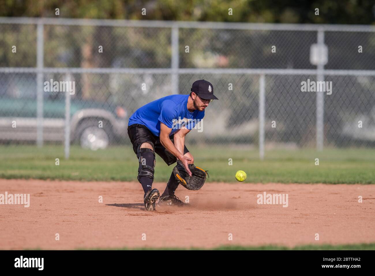 Jouer dans un jeu de softball de pas de Slo mixte, homme courant à la deuxième base. Banque D'Images