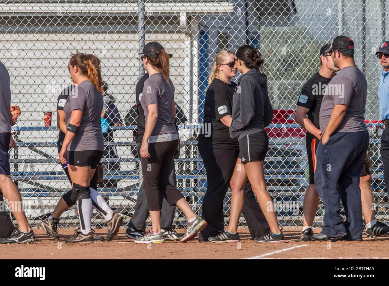 Jouer dans un jeu de softball de pas de Slo mixte, les équipes secouant les mains à la fin Banque D'Images