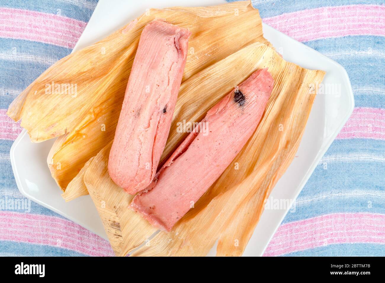 Tamale sucré, plat mexicain à base de pâte de maïs aromatisée à la raisins secs et à la fraise ou à l'ananas, enveloppé d'une feuille de maïs Banque D'Images