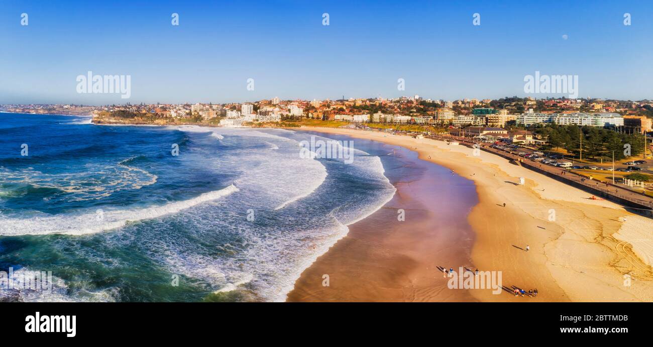 Large plage de sable de bondi à Sydney, sur la côte Pacifique, entourée par les banlieues est, dans une douce lumière du matin. Banque D'Images