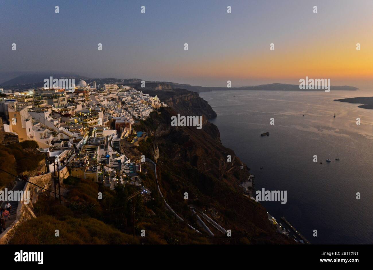 Coucher de soleil sur la mer et crépuscule dans les maisons blanches à Fira, Stantorini. Grèce Banque D'Images