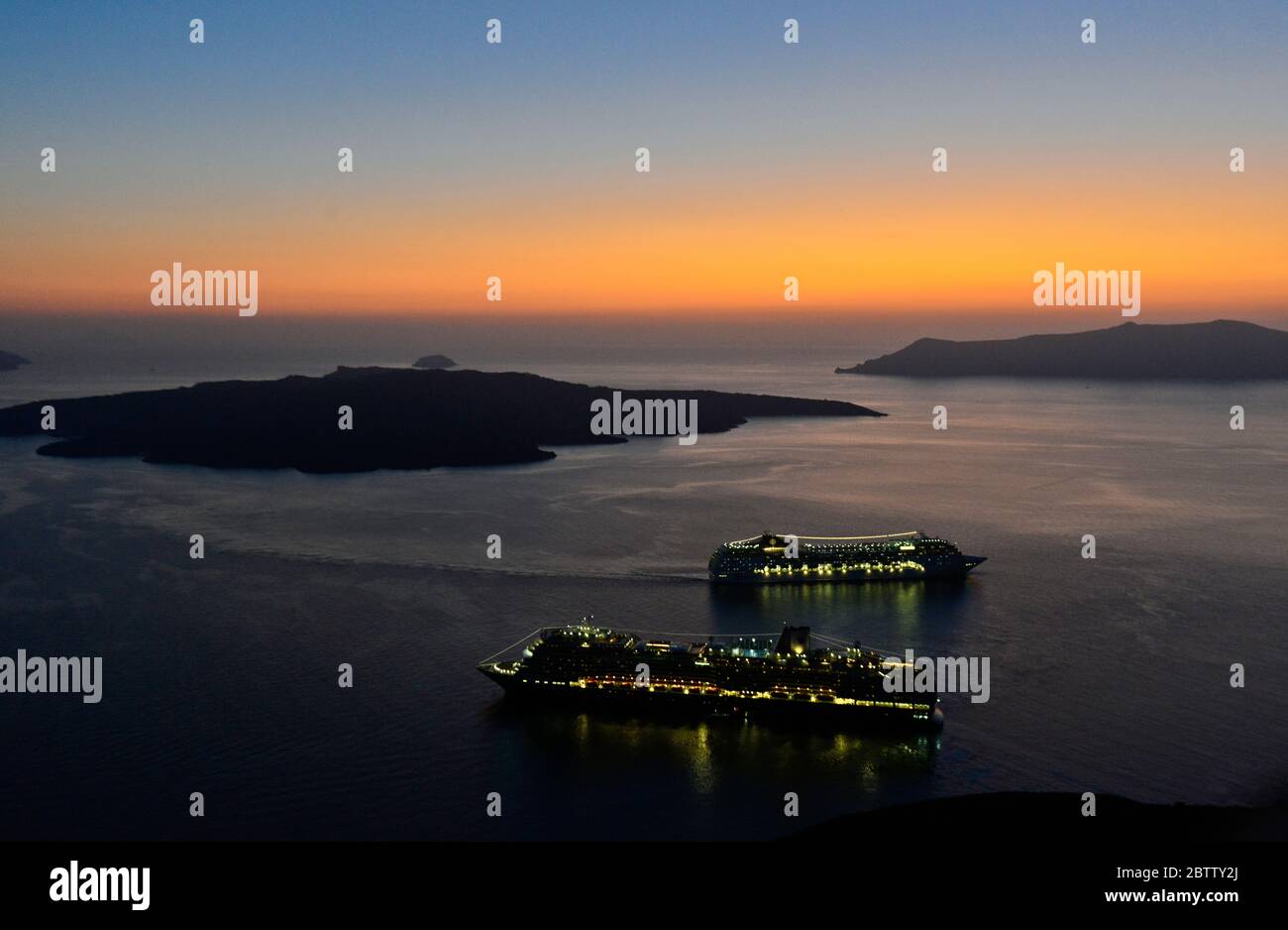 Coucher de soleil sur la caldeira de Santorin, avec 2 bateaux de croisière. Vue de Fira. Grèce Banque D'Images