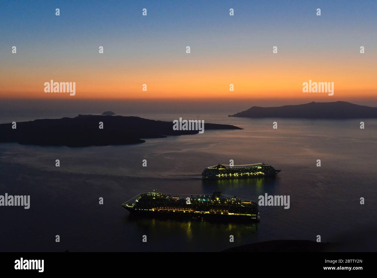 Coucher de soleil sur la caldeira de Santorin, avec 2 bateaux de croisière. Vue de Fira. Grèce Banque D'Images