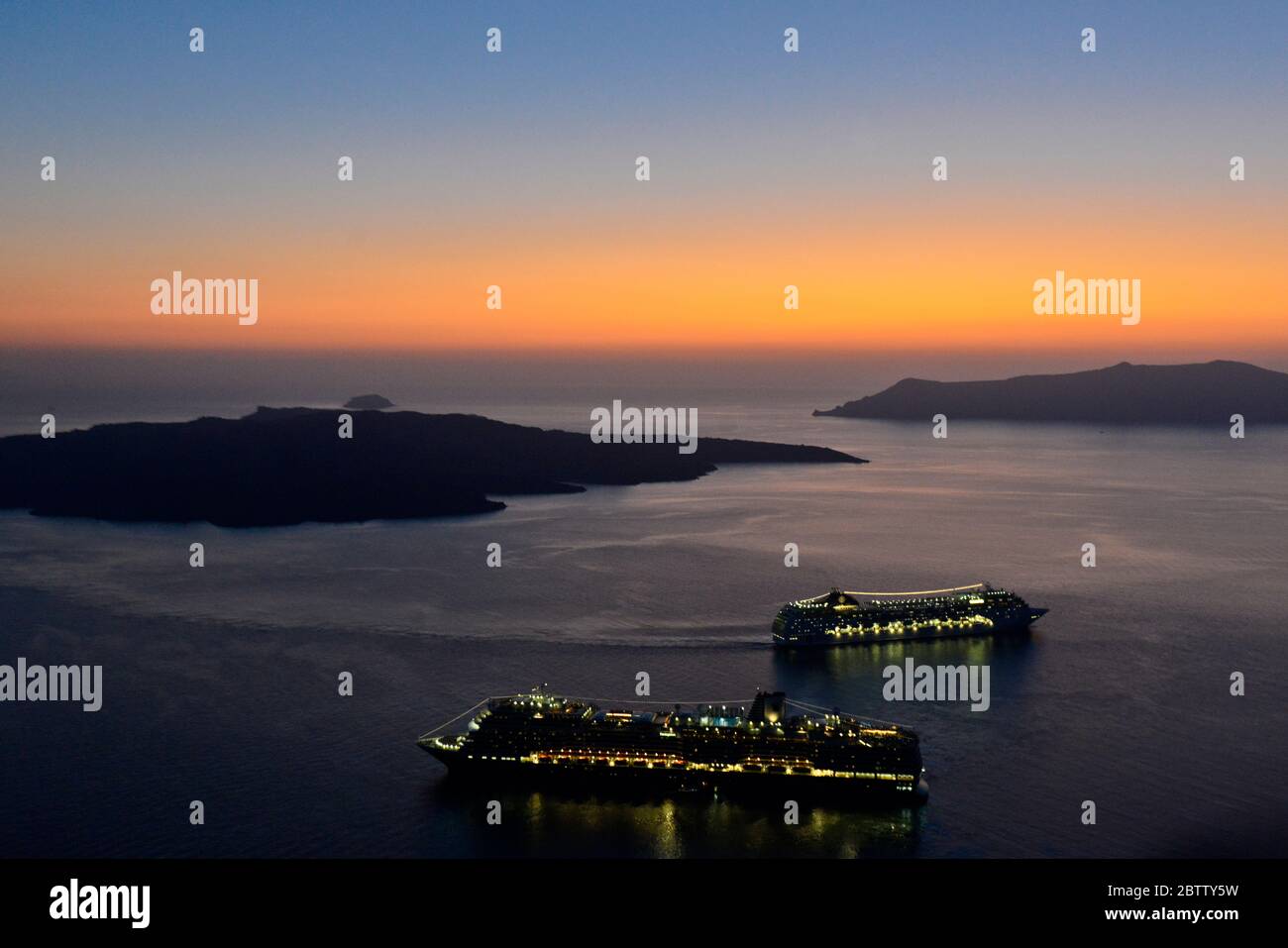 Coucher de soleil sur la caldeira de Santorin, avec 2 bateaux de croisière. Vue de Fira. Grèce Banque D'Images