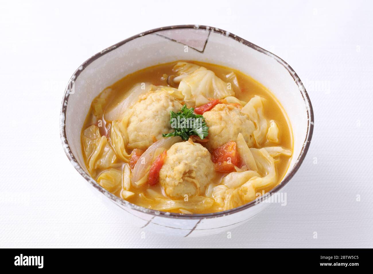 boule de viande avec soupe de légumes dans un plat sur fond blanc Banque D'Images