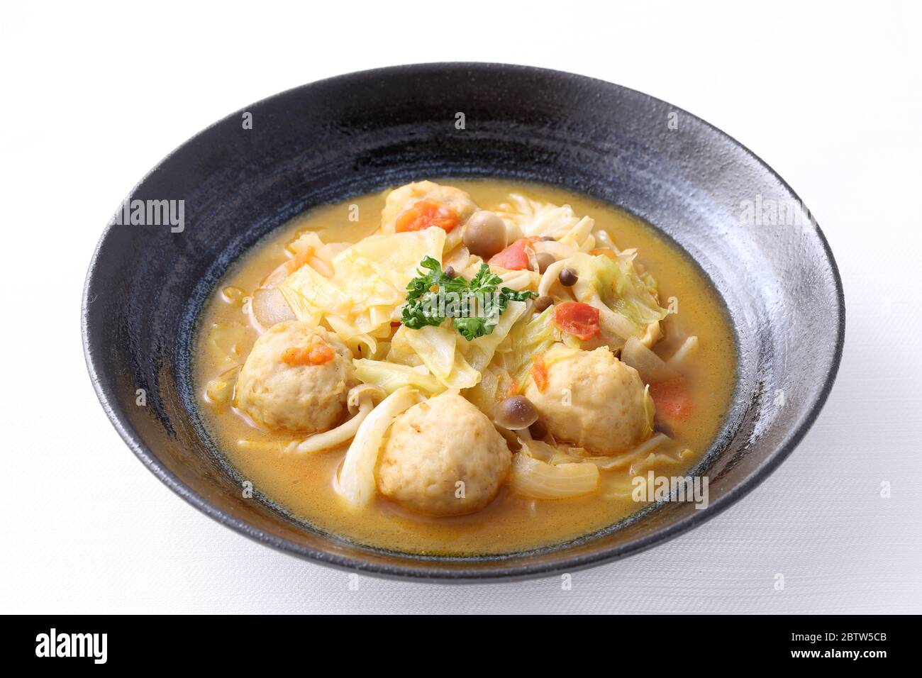 boule de viande avec soupe de légumes dans un plat sur fond blanc Banque D'Images