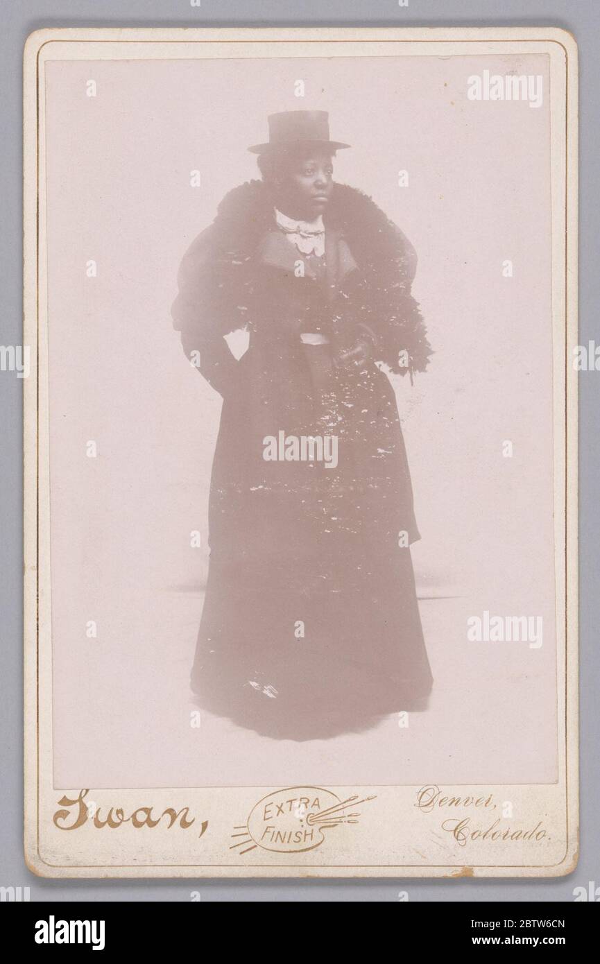 Carte de cabinet d'une femme non identifiée portant un chapeau et une vole de fourrure. Cette photographie en noir et blanc attribuée à Jutus C. Swan présente un portrait complet d'une femme non identifiée se tenant à un quart de tour à gauche. Elle regarde dans cette direction avec sa tête tournée presque dans le profil. Banque D'Images