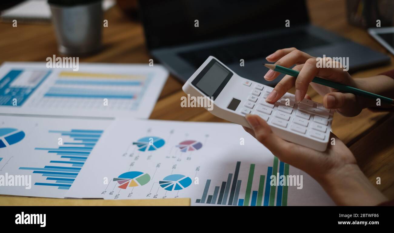 Gros plan Business Woman utilisant la calculatrice et l'ordinateur portable pour faire des mathématiques finance impôt, comptabilité, statistique concept de recherche Banque D'Images