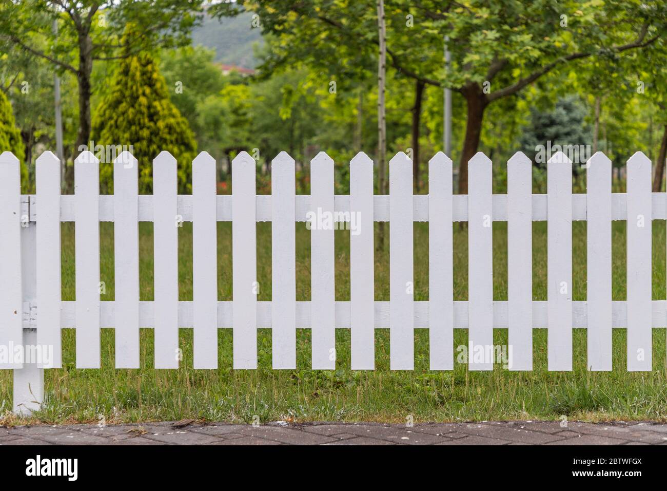 Clôtures blanches en bois autour du jardin Banque D'Images