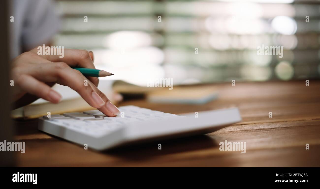 Femme d'affaires utilisant la calculatrice pour faire des mathématiques de la finance et le travail d'affaires, la fiscalité, la comptabilité, le concept de statistiques Banque D'Images