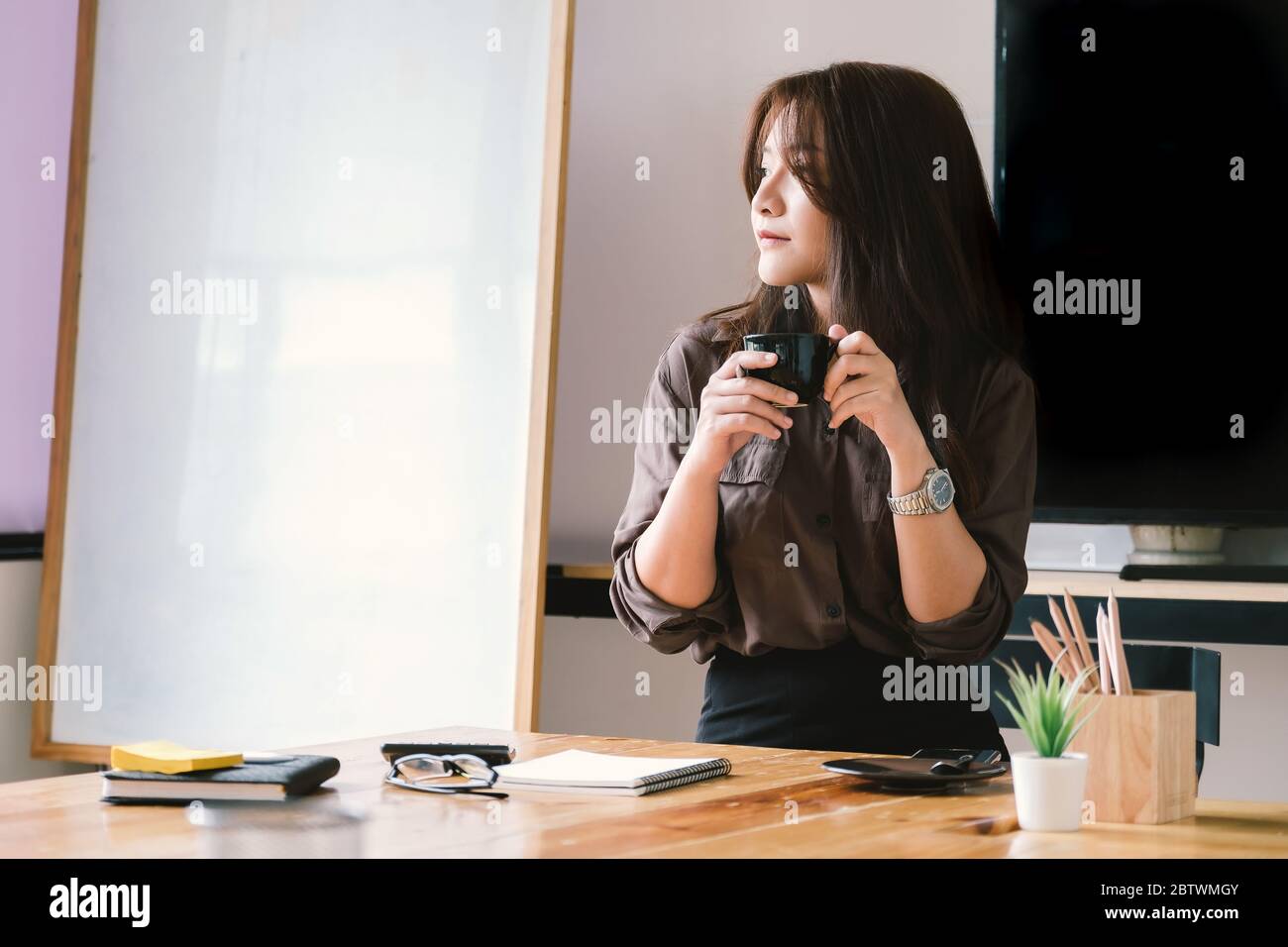 Pause café, femme d'affaires travaillant sur un bureau avec une calculatrice Banque D'Images