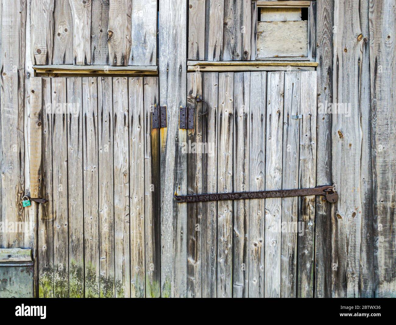 vue détaillée d'un ancien mur de grange en bois et de portes fermées avec cadenas rouillés Banque D'Images