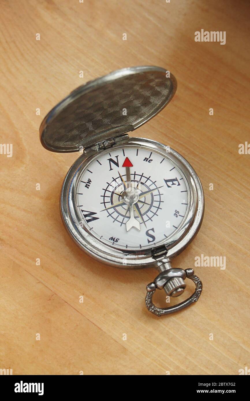 Gros plan d'une vieille boussole ancienne avec un fond de table en bois Banque D'Images