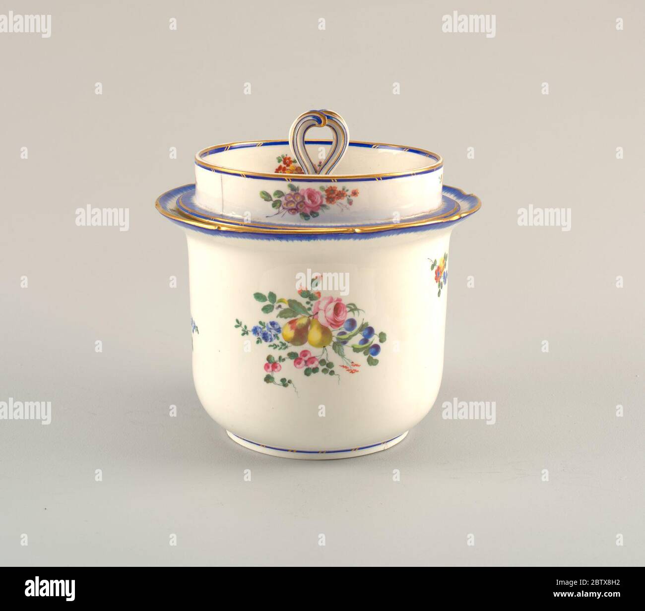 Glace à la crème glacée aux vaporisateurs floraux glace de la peau. Recherche en ProgressCylindrical, avec fond arrondi et pied cylindrique léger; bord évasant, en forme. Couvercle plat avec col cylindrique vertical et poignée à défilement. Décoré de grappes de fleurs et de fruits éparses, et de rayons bleus au bord. Banque D'Images