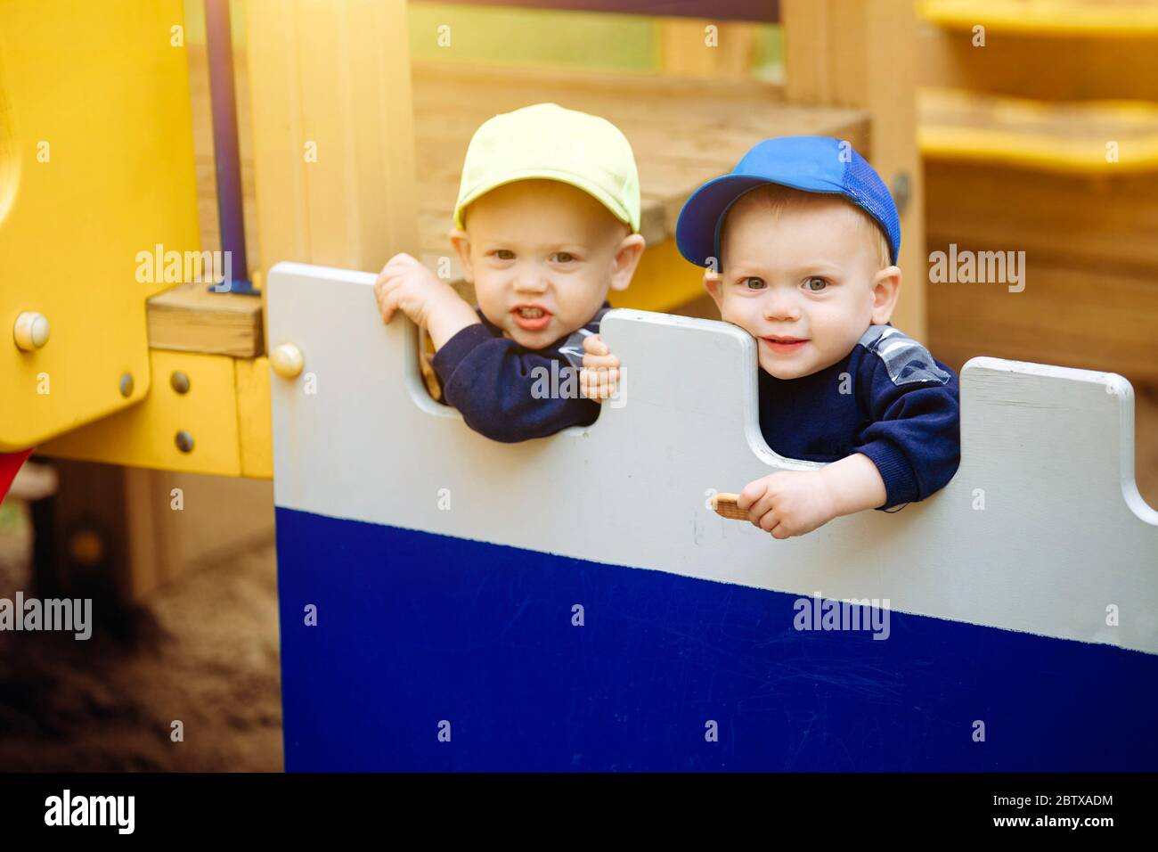 2 frères jumeaux jouent ensemble à l'aire de jeux, 1-2 ans Banque D'Images