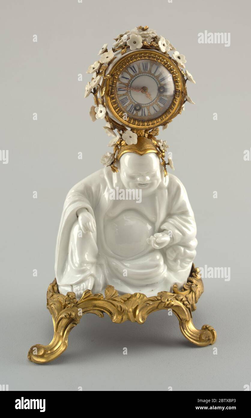 Horloge de manteau soutenu par un Bouddha de rire Hotei. Recherche en porcelaine blanche Progressa figure de Budai sur une base en bronze doré à quatre pattes; horloge circulaire en boîtier en bronze recouverte de petites fleurs en porcelaine blanche sur la tête de la figure. Banque D'Images