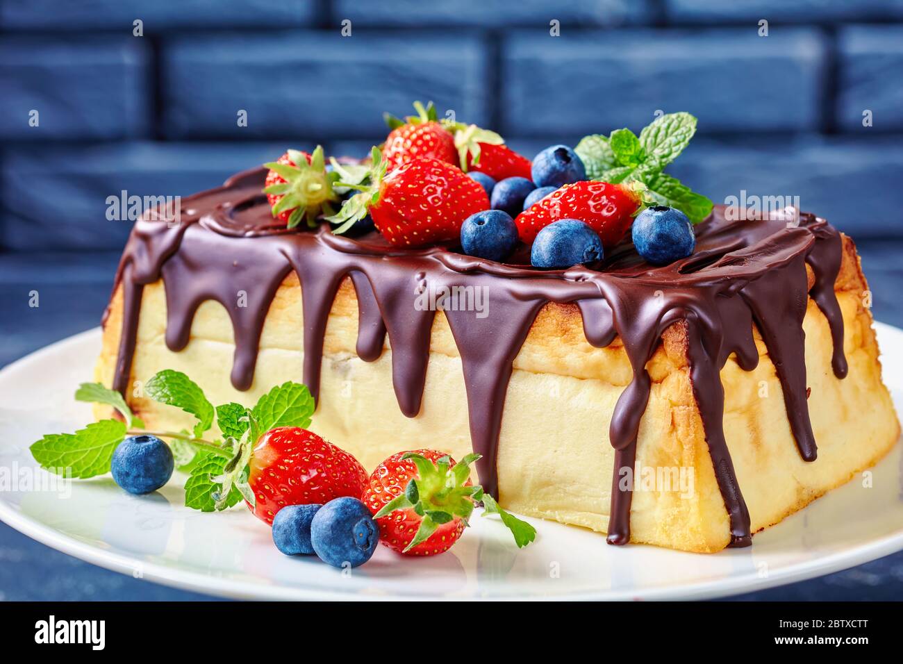 Cuisine D Europe De L Est Cheesecake Au Fromage Cottage Avec Glacage Au Chocolat Noir Sur Le Dessus Bleuets Frais Fraises Feuilles De Menthe Sur Un Gateau Blanc Photo Stock Alamy
