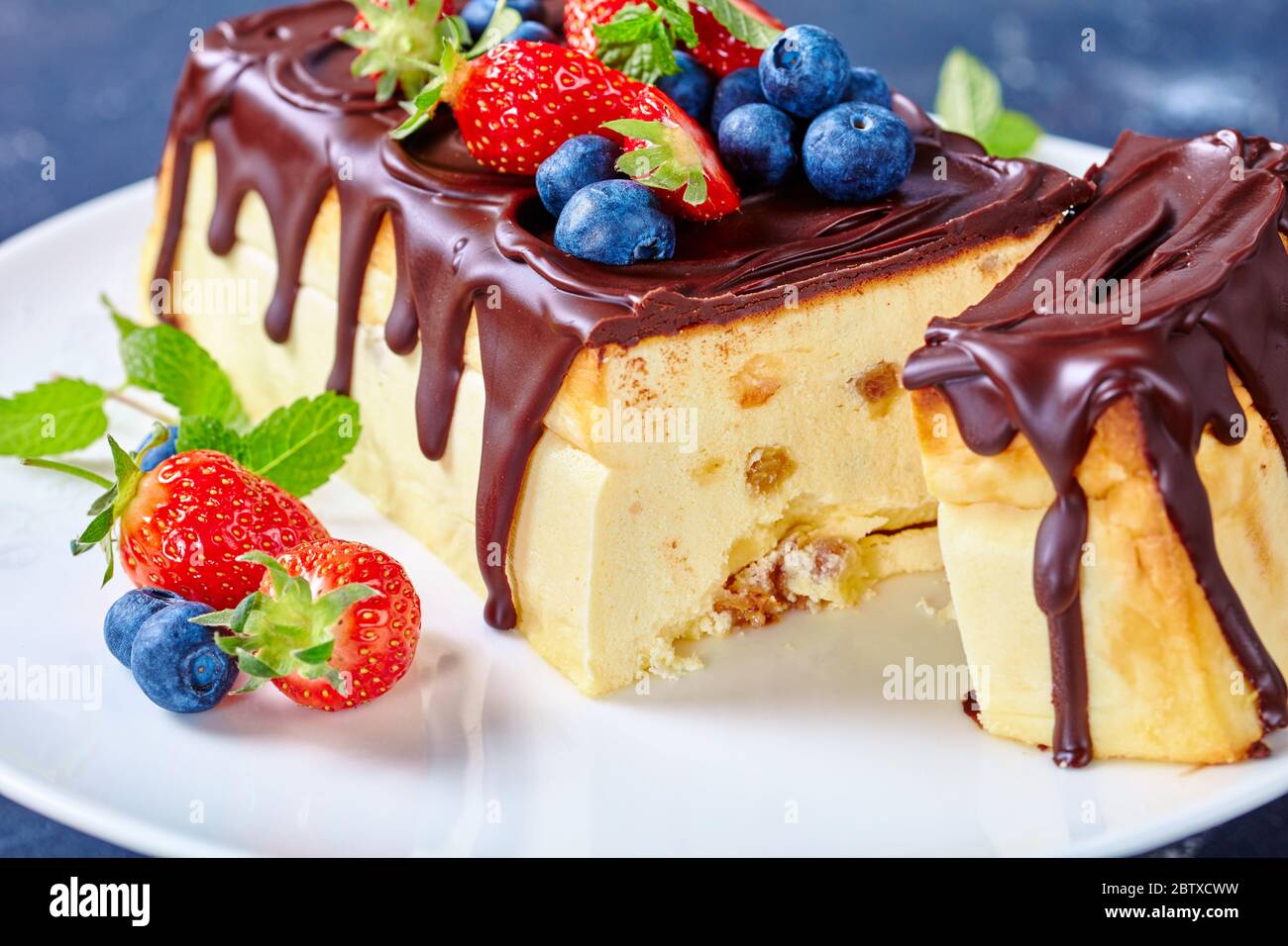 Cheesecake ukrainien de l'Ouest cheesecake lviv de fromage cottage, beurre, raisins secs nappés de chocolat servi avec des baies fraîches, bleuets, fraises Banque D'Images