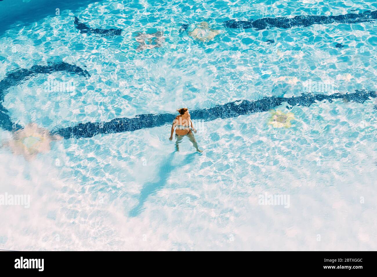 Des profils Caucasian Lady Woman Standing In Hotel Swimming Pool en journée ensoleillée. Locations dans l''hôtel. Banque D'Images