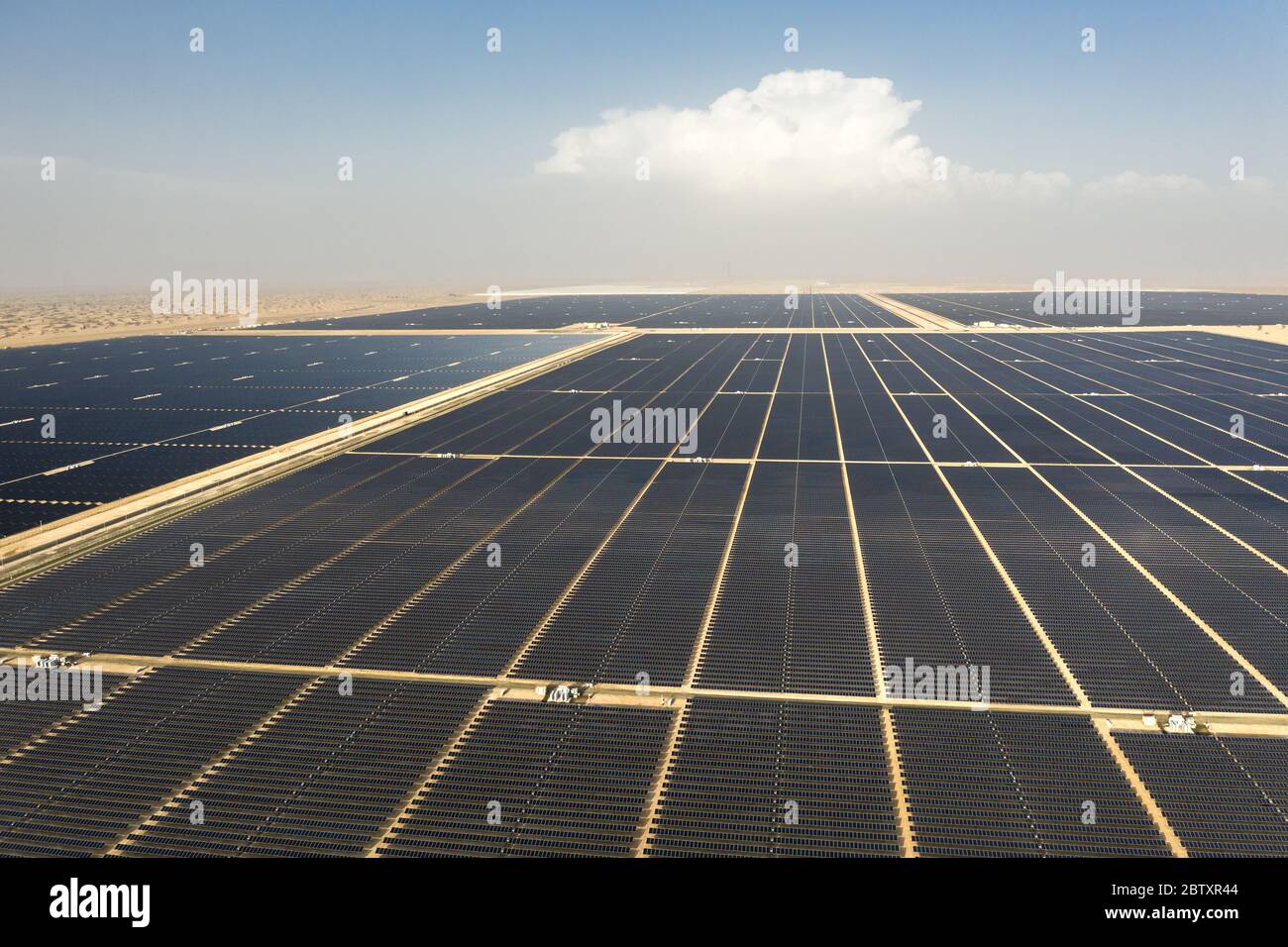 Vue aérienne d'un paysage avec une ferme de panneaux solaires photovoltaïques produisant une énergie renouvelable durable dans une centrale électrique désertique. Banque D'Images