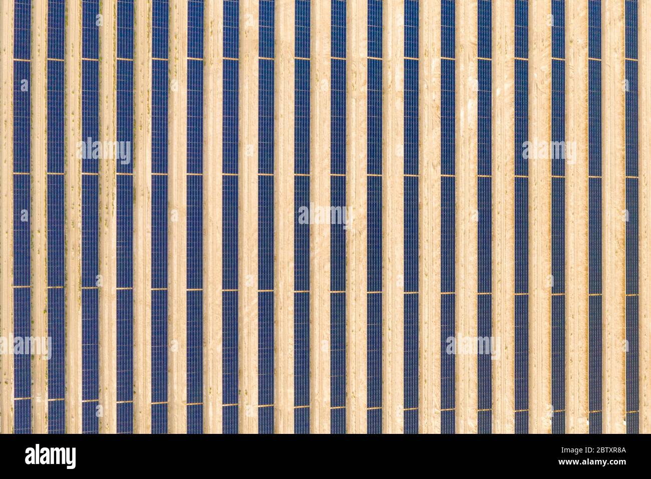 Vue aérienne verticale d'une ferme de panneaux solaires photovoltaïques produisant une énergie renouvelable durable dans une centrale électrique désertique. Banque D'Images