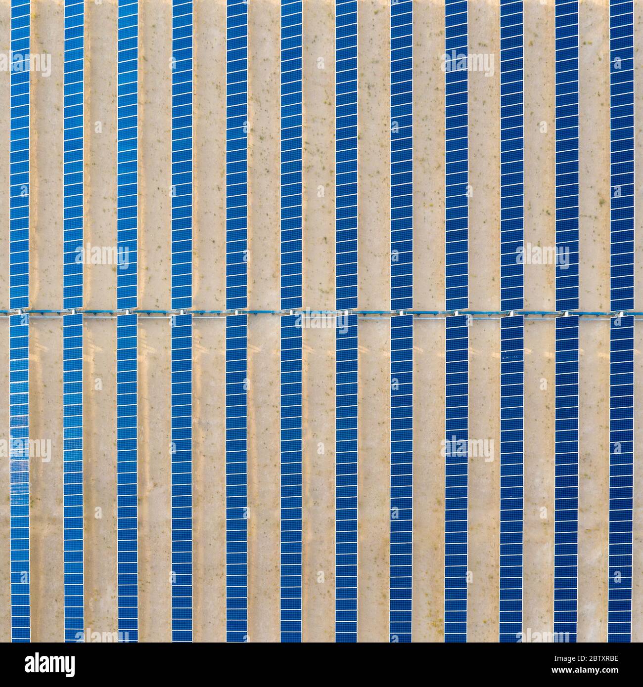 Vue aérienne verticale d'une ferme de panneaux solaires photovoltaïques générant une énergie renouvelable durable dans une centrale électrique désertique. Banque D'Images