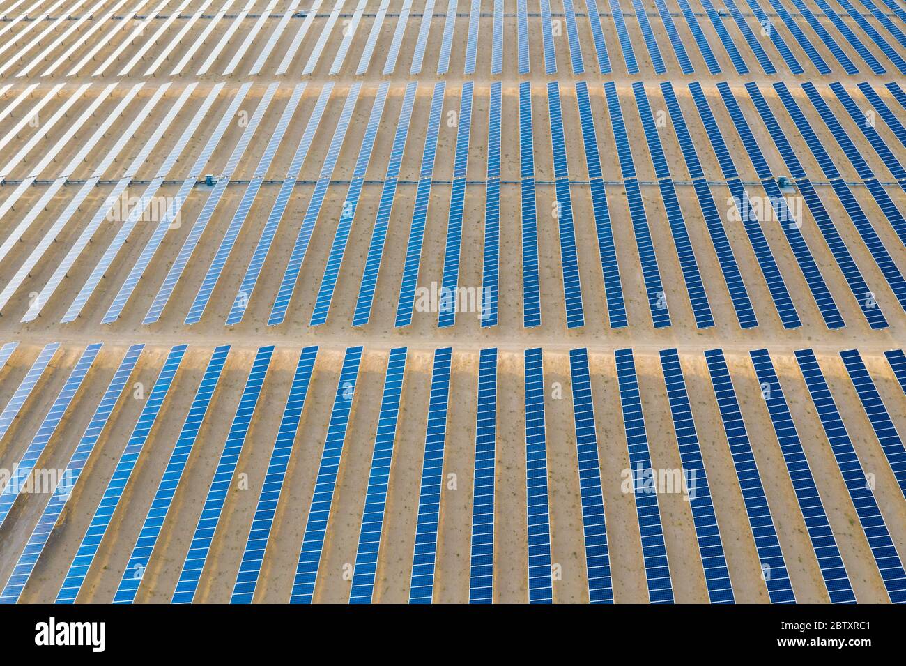 Vue aérienne d'une ferme de panneaux solaires photovoltaïques produisant une énergie renouvelable durable dans une centrale électrique désertique. Banque D'Images
