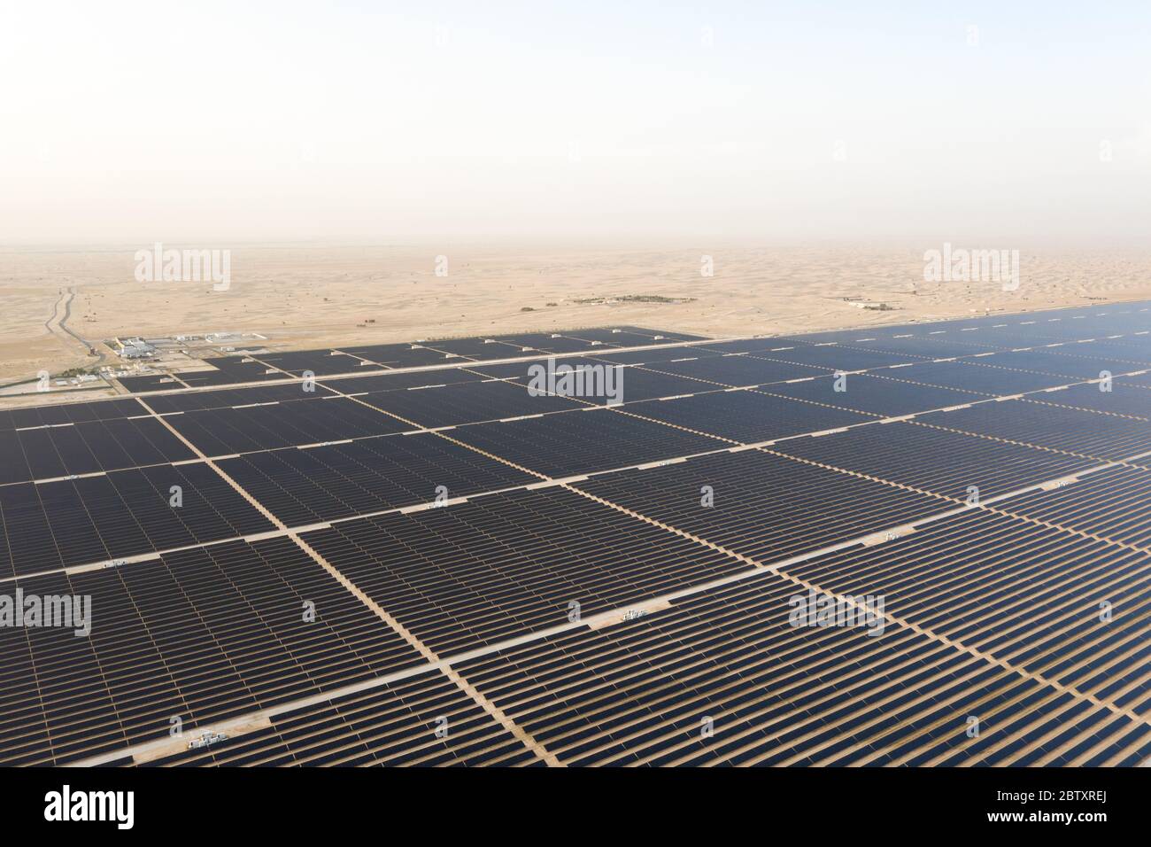 Vue aérienne d'un paysage avec une ferme de panneaux solaires photovoltaïques générant une énergie renouvelable durable dans une centrale électrique désertique. Banque D'Images